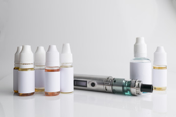 Isolated e liquid bottles and electronic cigarette, e cig for vape devices over a white background
