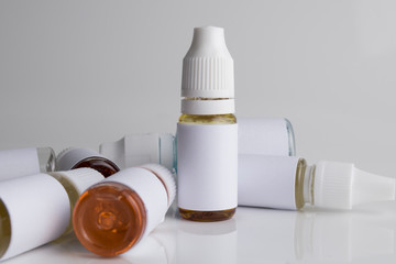 Isolated e liquid bottles and electronic cigarette, e cig for vape devices over a white background