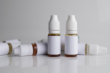 Isolated e liquid bottles and electronic cigarette, e cig for vape devices over a white background