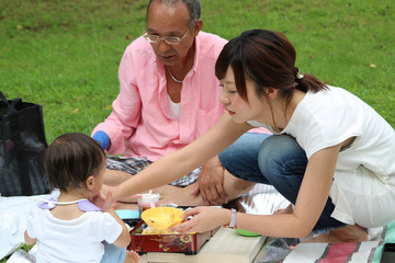 公園でお弁当を食べる家族