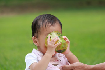公園で水分補給する赤ちゃん