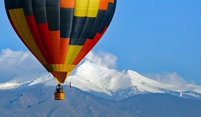 Acrylic prints Balloon Hot air balloon with Colorado's Rocky Mountains in the background.