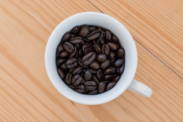 Roasted coffee beans in a cup.