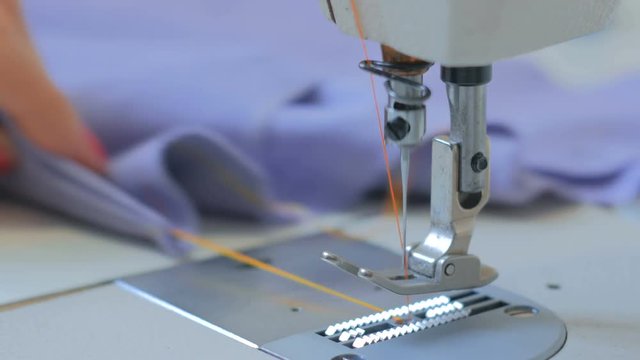 Professional tailor, fashion designer sewing clothes with sewing machine at atelier. Fashion and tailoring concept