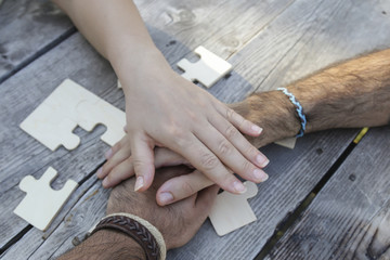 Obraz premium Business partnership or teamwork concept with a business people presenting a matching puzzle piece as they cooperate on finding an answer and solution, close up of their hands. 