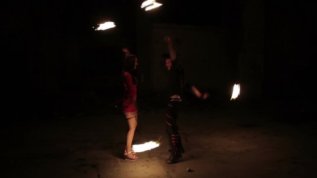 Two actors show fire show in an old aircraft hangar.