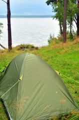 Camping tent on coast of lake.