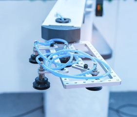 robot with vacuum suckers picks the mibile item from the conveyor in manufacture factory