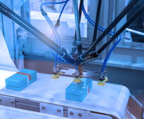 robot with vacuum suckers picks the mibile item from the conveyor in manufacture factory