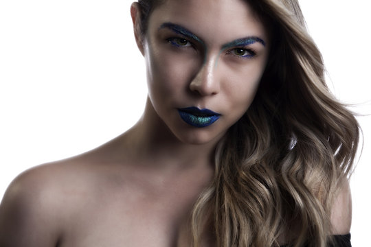 a Hispanic female model wearing vibrant neon blue lipstick and black dress. she has big green eyes and wears a bluish green liner and shadow with great long flowing hair