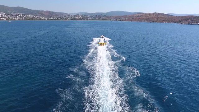 Speed boat doing watersports.