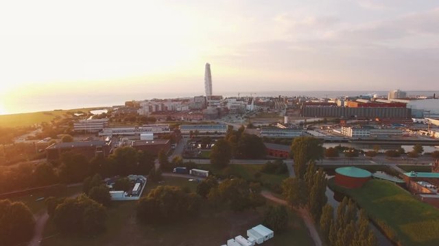 Aerial view of Malmo cityscape at sunset. Drone shot flying up over Malmo city, Sweden, Turning Torso building in the background