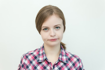 Caucasian young woman with a gloomy, irritated, unhappy face