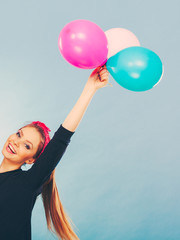 Lovely smiling girl holds colorful balloons.