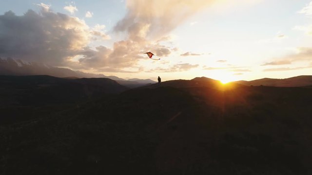 Silhouette Of woman flying kite at sunset time. 4k slow motion