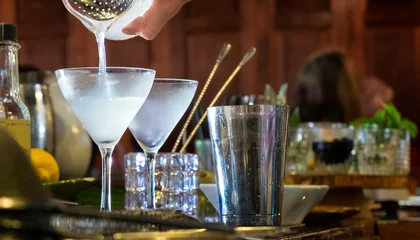 Rolgordijnen Cocktail pouring into a glass. Liquid motion blur. Close up bar scene. © Crin