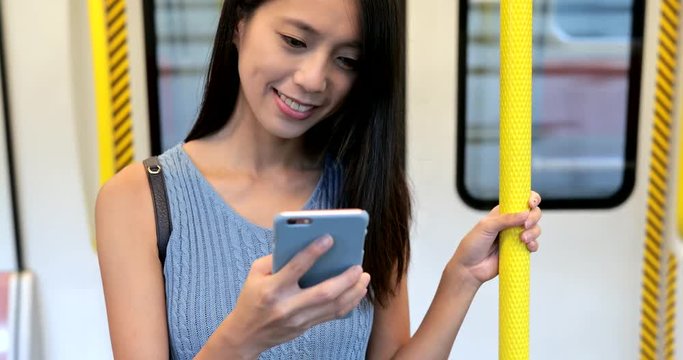 Woman looking at cellphone on train
