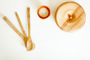 Wooden kitchen utensils on a white table.