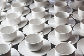 Large group of white coffee tea cups arranged in rows
