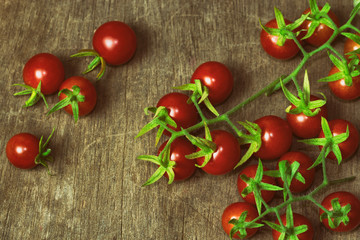 Fresh cherry tomato on rustic wood table. Top view cherry tomato for background or wallpaper. Prepare fresh cherry tomato for home cooking look so delicious. Top view with copy space in vintage tone.