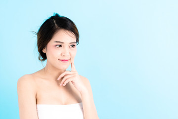 Asian young beautiful confidence woman smiling portrait touching her face over blue background.