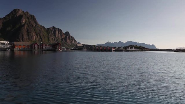 Picturesque fishing port in Henningsvaer on Lofoten islands, Norway with typical red wooden buildings and small fishing boats