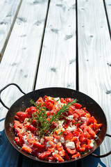 pepperand feta with rosemary and thyme in iron pan