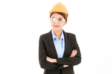 Young attractive confident asian woman, orange safety hat, safety glass, black suit, blue shirt on white background with arm cross.