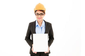 Young attractive confident asian woman, orange safety hat, glass, black suit, blue shirt on white background holding white card.