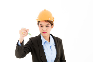 Young confident asian woman, orange safety hat, black suit, blue shirt on white using pen.