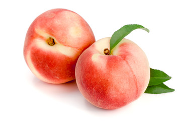 Two peaches with green leaf isolated on white background