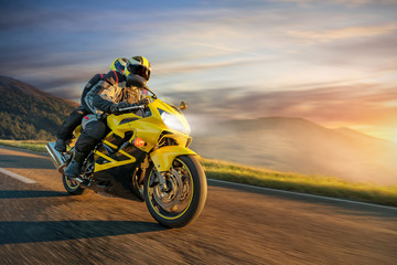 Naklejka premium Motocykliści na sportowym motocyklu jeżdżącym w alpejskim krajobrazie.