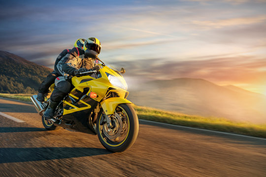 Fototapeta Motorbikers on sports motorbike riding in alpine landscape.