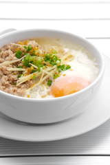 vertical pork chops rice porridge or congee with soft boiled egg and vegetable in the white bowl with spoon on the aluminium table for delicious breakfast and clean food in the morning