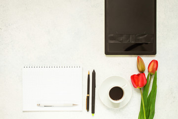 Flat lay photo of office desk with laptop, tulips, notebook and coffee. Selective focus. Copy space. Top view