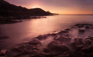 Sunrise at Bracelet Bay, featuring the Mumbles Lighthouse in Swansea, South Wales, UK