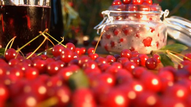 Cherry juice on the background of growing cherries.

Slow motion. The smooth glide of the camera ( from right to left ) along the table with a cherries and juice.