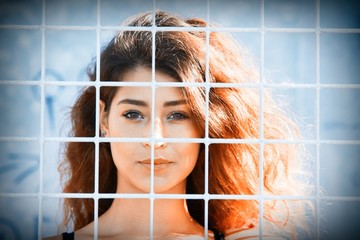 Young woman behind the metal mesh