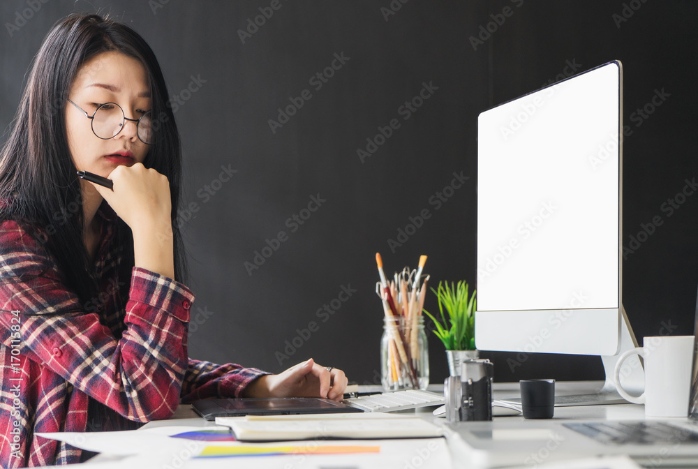 Aufkleber female graphic designer working on computer while using graphic tablet at desk in the office