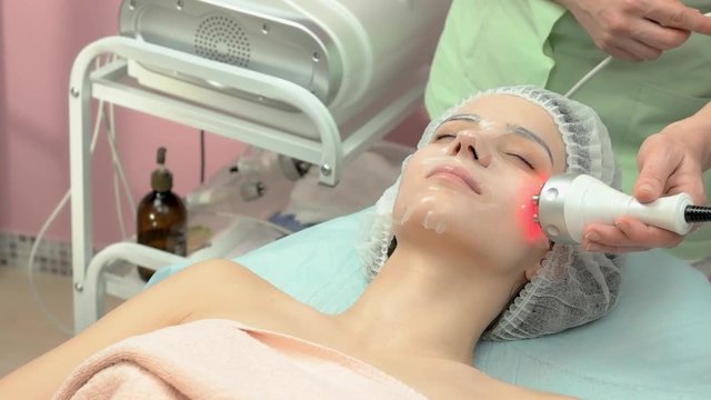 Radio frequency face lift. Young woman undergoing skin therapy.