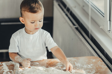 A child with a rolling pin at the table