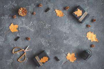 Autumn composition. Gifts, autumn golden leaves, pine cones, accessories on black background. Flat lay, top view