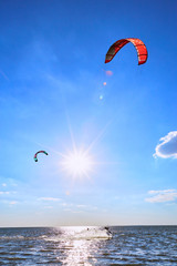 Man riding a kite surfing on the waves in the summer.