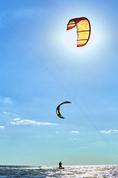 Man riding a kite surfing on the waves in the summer.