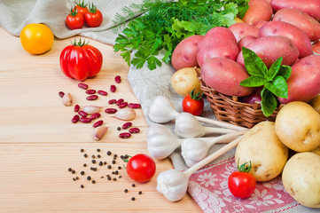 Potatoes and other vegetables on a wooden table