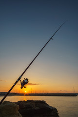 Fishing at dawn/Fishing rod in the rocks of the Roc de Sant. Gaieta at dawn