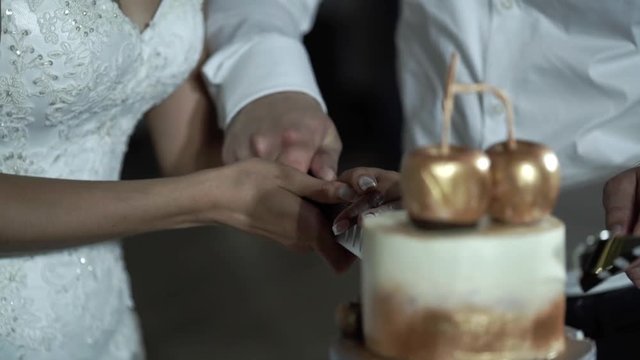 Cutting piece of wedding cake slowmotion
