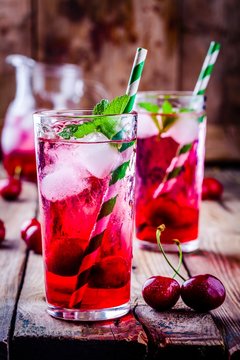 ice refreshing cherry lemonade in glass with ice cubes and mint