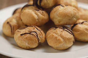 closeup profiteroles with fine dark chocolate on plate
