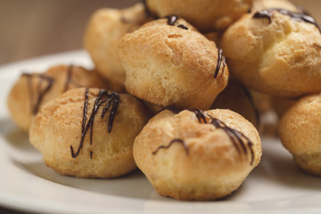 closeup profiteroles with fine dark chocolate on plate